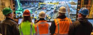 a focused construction training environment showcases a diverse group of individuals engaged in an interactive crane certification workshop, surrounded by cranes and safety equipment, illuminated by bright artificial lighting that emphasizes the professionalism and importance of safety in the industry.